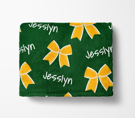 a green blanket with yellow bows and the name "Jesslyn" printed on it.