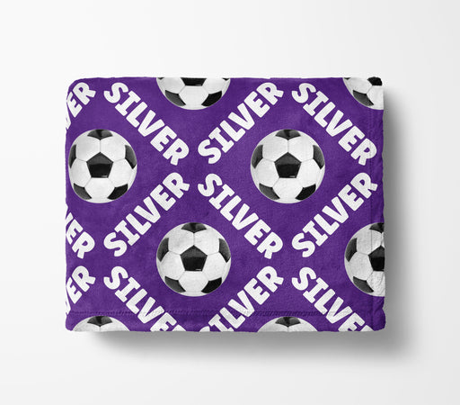 a purple blanket with a repeating pattern of soccer balls and the word "Silver" written on it.