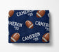 a navy blue blanket with a repeating pattern of footballs and the name "Cameron #99" printed on it.