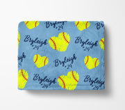 A blue blanket with yellow softball-shaped hearts and the name "Bryleigh" printed on it.