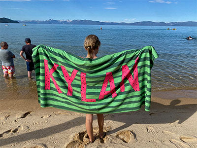 a girl holding a towel with the word ajax on it