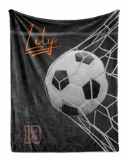 A black and white image of a soccer ball being caught in a net, with the name "Lily" written above it.