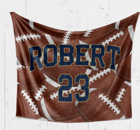 A personalized blanket featuring a football design with the name "ROBERT" and the number "23" printed on it.