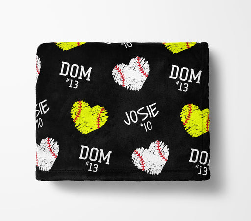 a black blanket with a repeating pattern of baseballs and hearts in yellow and white colors.