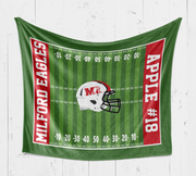 A green towel with red and white text and an image of a football helmet on it.