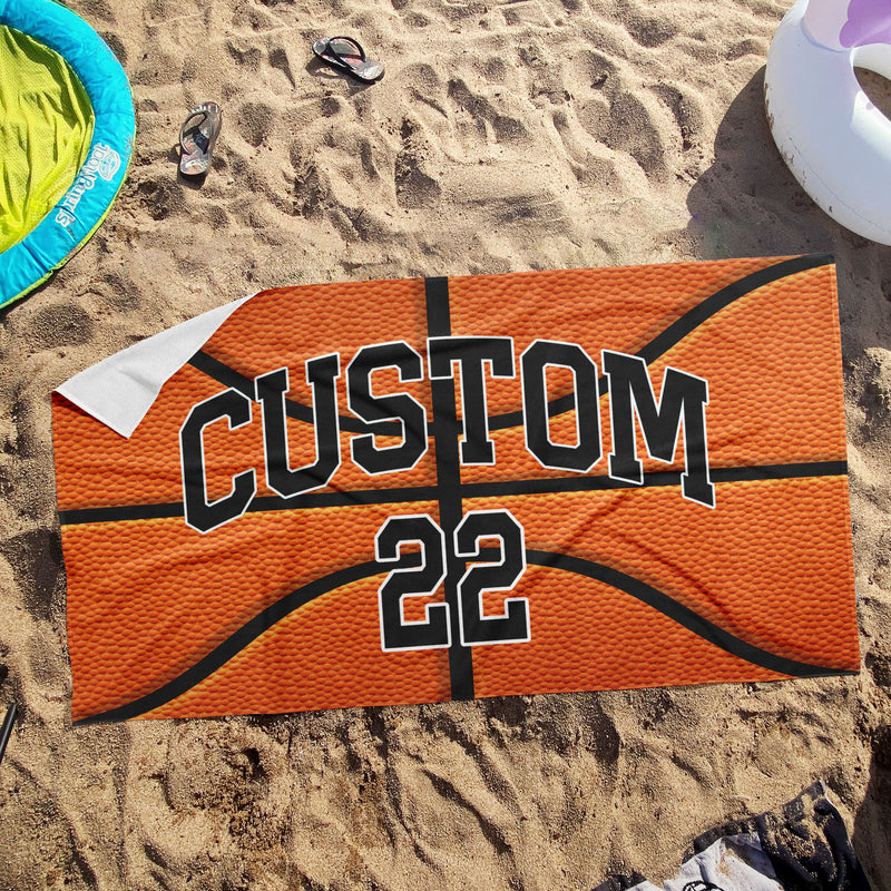 a towel with a basketball on it laying in the sand