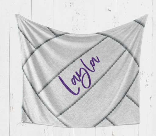A gray and white striped blanket with the name "Layla" written in purple cursive on it.