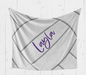 A gray and white striped blanket with the name "Layla" written in purple cursive on it.