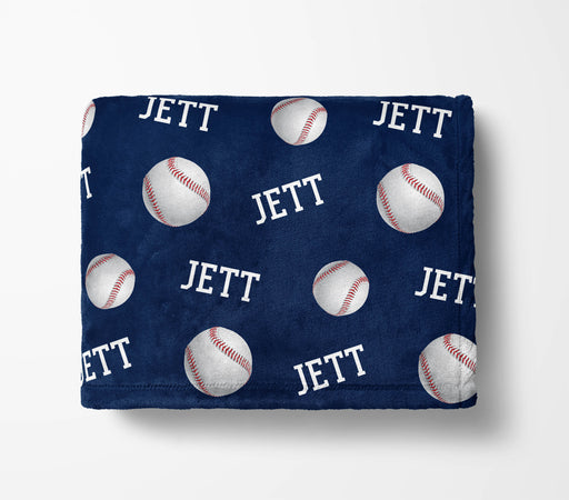 a navy blue blanket with a repeating pattern of baseballs and the word "Jett" printed on it.