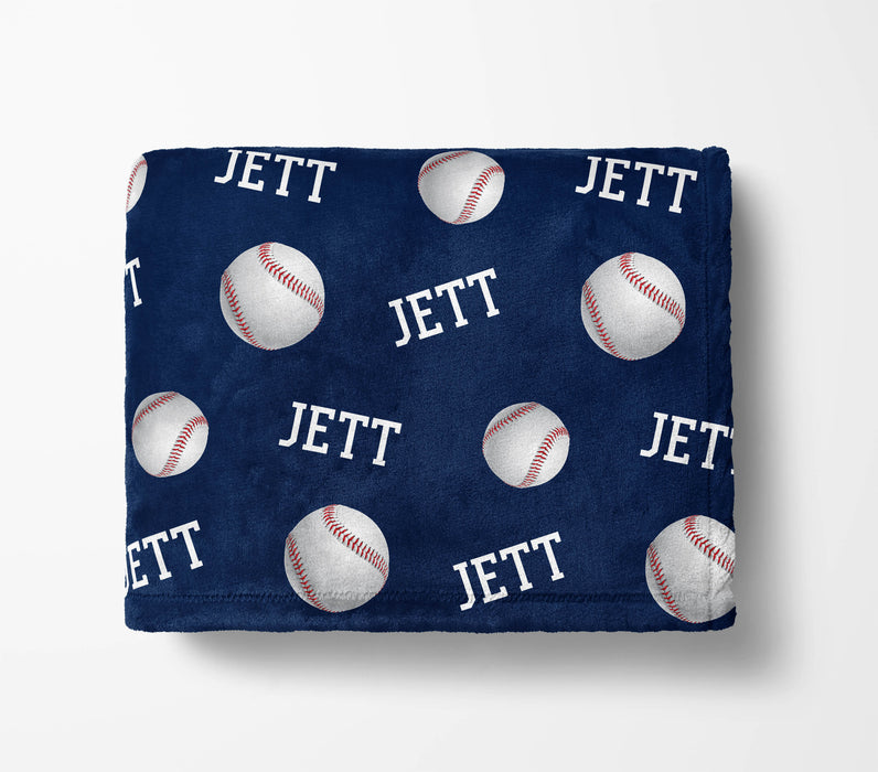 a navy blue blanket with a repeating pattern of baseballs and the word "Jett" printed on it.