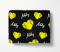 A black blanket with a repeating pattern of yellow softball hearts and the name "Abby" written in white.