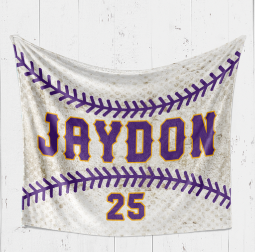 A white banner with purple text and a baseball design, hanging on a white wooden wall.