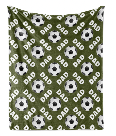 a repeating pattern of soccer balls and the word "DAD" on a green fabric background.