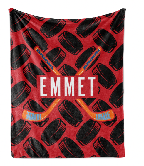A red and black blanket with a repeating pattern of hockey sticks and puck silhouettes. The word "EMMET" is prominently displayed in the center of the blanket.