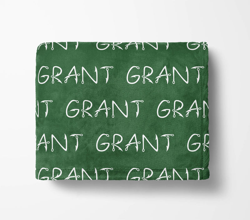 The image is a green blanket with the word "GRANT" repeated multiple times in white text.