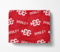 The image is a red blanket with white text and logos printed on it.